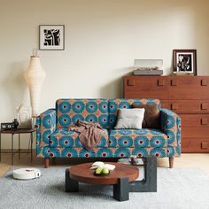 a living room with a blue couch and coffee table in front of a large window