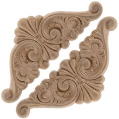 two carved wood pieces with swirl designs on each side, one is beige and the other has