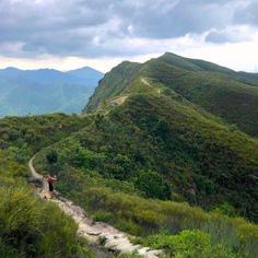 a person walking up a trail on the side of a mountain