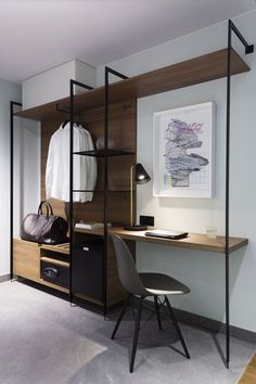 a room with a desk, chair and shelves on the wall in front of it