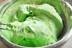 a metal bowl filled with green ice cream