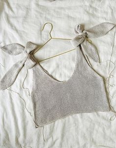 a white shirt with a bow on it and some string attached to the back of it