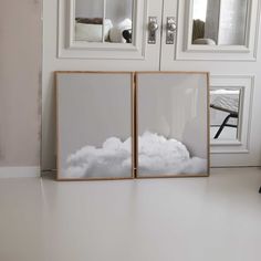 two framed pictures sitting on top of a white floor next to a door and window