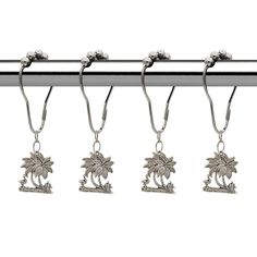 four silver hooks hang from a metal bar with palm trees and flowers on the ends