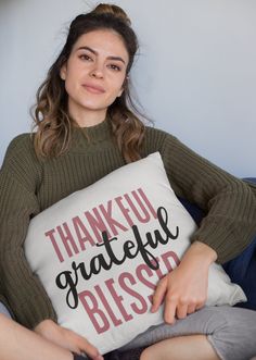 a woman sitting on a couch holding a pillow with the words, thank grateful blessed