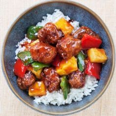 a blue bowl filled with meat and veggies on top of steamed white rice