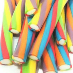 multicolored candy sticks are stacked on top of each other