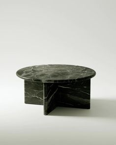 a black marble coffee table sitting on top of a white floor