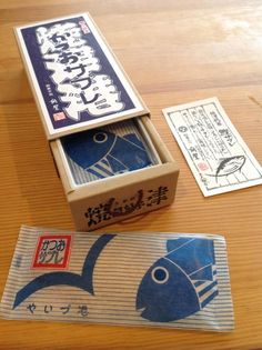 an open box sitting on top of a wooden table next to some cards and papers