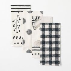 three napkins with black and white designs are lined up against a white background,