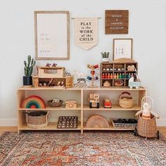 a room with a rug, shelves and pictures on the wall