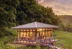 a small cabin in the middle of a lush green field