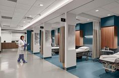 a hospital room filled with beds and nurses walking through the hallway to an exam table