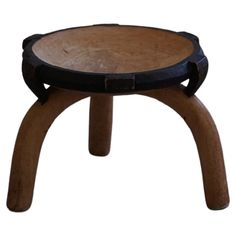 a small wooden stool with black leather straps on it's legs and an open top