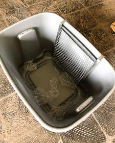 a bucket filled with water sitting on top of a wooden floor