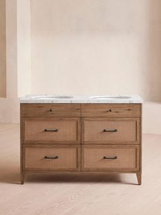 a bathroom vanity with marble top and two sinks in the same color as it stands against a beige wall