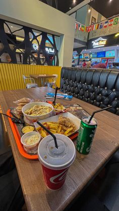 a table topped with lots of food and drinks next to each other on top of a wooden table