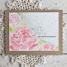 a close up of a card on a wooden surface with crocheted doily