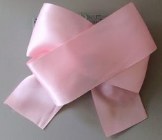 a pink bow on top of a gray table next to a computer mouse and keyboard