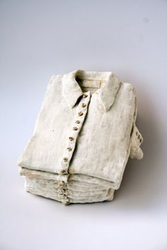 a stack of folded white linens sitting on top of each other in front of a white background