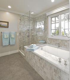 a bath room with a tub a sink and a window