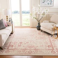 a living room filled with furniture and a large rug on top of a hard wood floor