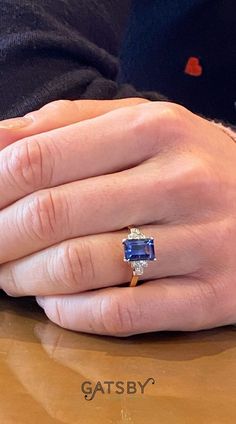 a close up of a person's hand with a ring on top of a table