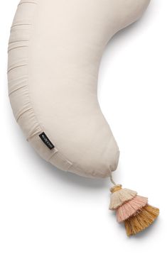 a white pillow with tassels hanging from it's side on a white background