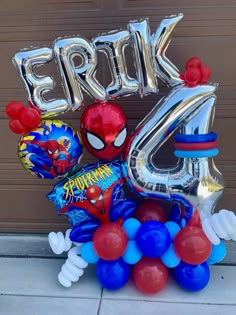 spiderman balloon bouquet with helium balloons and the number four in front of a garage door