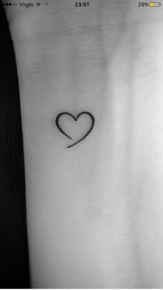 a small heart tattoo on the left side of the arm, with an arrow in the middle