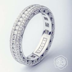 an intricately designed wedding ring with diamonds on the sides and inlays that spell love