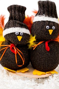 two knitted birds sitting on top of each other in front of white fluffy carpet