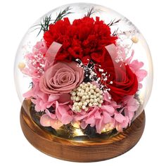 a snow globe filled with flowers and greenery