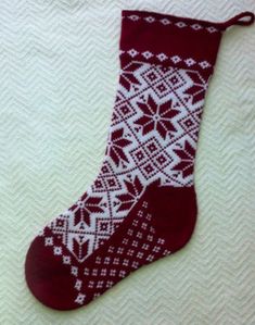 a red and white knitted christmas stocking with snowflakes