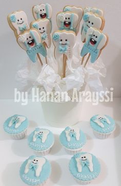 cupcakes and cookies in the shape of toothbrushes are arranged on a table