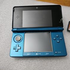 a blue nintendo wii game system next to a cell phone