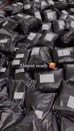 bags filled with black plastic sitting on top of a floor