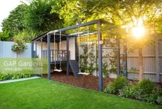 a backyard with a swing set, grass and trees in the back yard at sunset