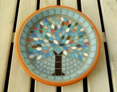 an orange and blue bowl with a tree on it