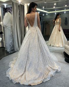 a woman is looking at her wedding dress in the mirror