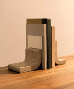 a bookend made out of concrete on top of a wooden table next to a white wall