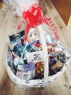 a basket filled with assorted items on top of a wooden floor next to a table