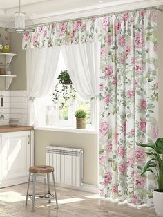 a white kitchen with pink flowers on the curtains