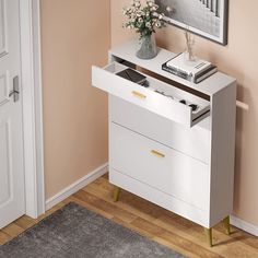 a white cabinet with two drawers in front of a door and a rug on the floor