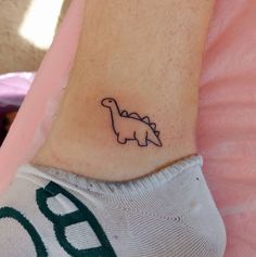 a small dinosaur tattoo on the ankle