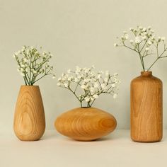 three wooden vases with white flowers in them