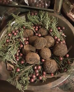 nuts and berries are arranged on a platter with pine cones, red berries, and cinnamons