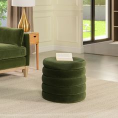 a green chair and ottoman in a living room with a book on the end table