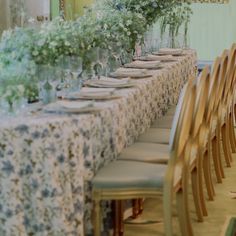 a long table is set up with flowers and place settings for dinner party guests to enjoy