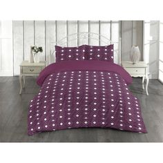 a purple comforter set with white hearts on it